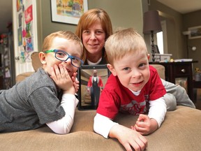 Nicole Code, with her sons Duncan, left, and Brock, holds a picture of her husband.