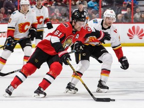 Mark Stone of the Senators protects the puck from Matt Stajan of the Flames in a game on March 9. Stone's leg was injured in that contest and he hasn't played since.