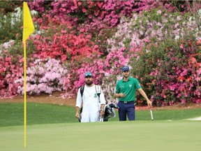 Adam Hadwin of Canada waits with caddie Joe Cruz on the 13th hole during the second round of the Masters on Friday.