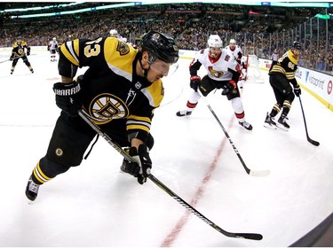 Christian Wolanin of the Senators tries to reduce the space available to Brad Marchand of the Bruins during the first period of play in Boston on Saturday night.