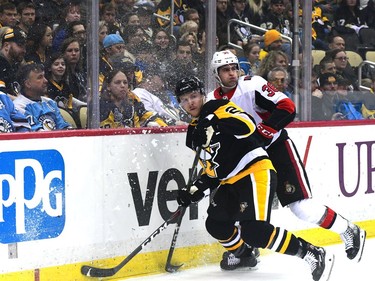 Chad Ruhwedel of the Penguins is checked by Colin White of the Senators in the first period of Friday's game in Pittsburgh.