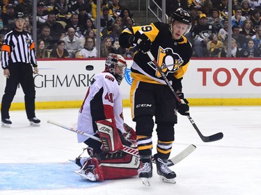 Jake Guentzel of the Penguins jumps in front of Senators netminder Craig Anderson as he tries to get out of the way of a shot during the second period.