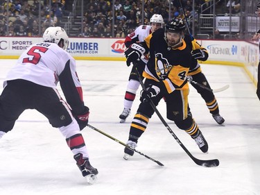 Zach Aston-Reese of the Penguins shoots the puck past Cody Ceci of the Senators in the third period.