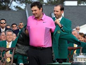 Patrick Reed of the United States is presented with the green jacket by Sergio Garcia of Spain during the green jacket ceremony after winning the 2018 Masters Tournament at Augusta National Golf Club on April 8, 2018 in Augusta, Georgia.