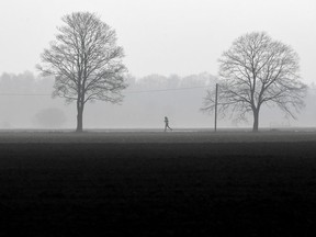 A jogger runs in the fog.