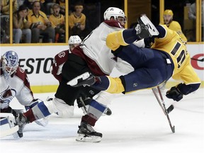 Avalanche defenceman Patrik Nemeth dumps  Predators centre Colton Sissons out of the way as goaltender Jonathan Bernier blocks a shot during the second period on Saturday.