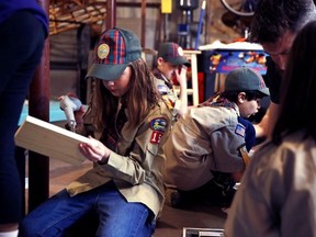 In a Thursday, March 1, 2018 photo, Tatum Weir, left, sets to drill a pilot hole while building a tool box during a cub scout meeting in Madbury, N.H.