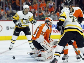 The puck bounces back out of the net behind Flyers goalie Brian Elliott after Penguins' Justin Schultz, not pictured, scored a power play goal during Game 3 of their NHL playoff series in Philadelphia, Sunday, April 15, 2018. (Tom Mihalek/AP Photo)