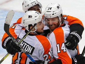Philadelphia Flyers' Sean Couturier celebrates his goal with Scott Laughton and Wayne Simmonds during Game 5 against the Pittsburgh Penguins on April 20, 2018