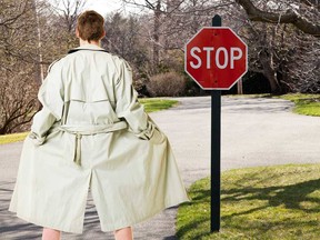 In this combination stock photo, a man in a trench coat reveals himself in an intersection.