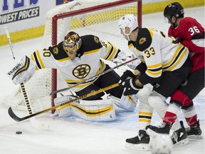 Bruins defenceman Zdeno Chara (33) ties up Senators centre Colin White (36) as goaltender Tuukka Rask clears the puck during the first period of a game in Ottawa on Jan. 25.