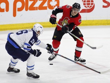Ottawa Senators Mark Borowiecki (74) shoots the puck past Winnipeg Jets Blake Wheeler (26) during first period NHL hockey action at the Canadian Tire Centre in Ottawa on Monday, April 2, 2018.