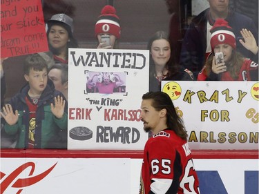 CORRECTS YEAR Fans hold up signs in support of Ottawa Senators captain Erik Karlsson (65) during the warm-up before NHL hockey action against the Winnipeg Jets at the Canadian Tire Centre in Ottawa on Monday, April 2, 2018.