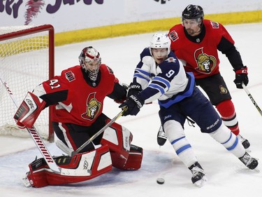Winnipeg Jets Andrew Copp (9) tries to score on Ottawa Senators goaltender Craig Anderson (41) while being chased by defenceman Cody Ceci (5) during second period NHL hockey action at the Canadian Tire Centre in Ottawa on Monday, April 2, 2018.