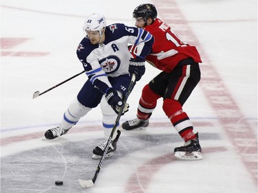 Winnipeg Jets Mark Scheifele (55) skates with the puck while being pursued by Ottawa Senators Tom Pyatt (10) during second period NHL hockey action at the Canadian Tire Centre in Ottawa on Monday, April 2, 2018.