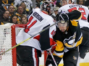 Pittsburgh Penguins' Josh Jooris, center, is pushed by Ottawa Senators' Thomas Chabot into goaltender Craig Anderson, left, during the second period of an NHL hockey game Friday, April 6, 2018