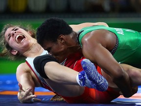 Nigeria's Aminat Adeniyi, right, wrestles with Canada's Michelle Fazzari in women's FS 62kg wrestling finals at the Commonwealth Games on Gold Coast, Australia, Saturday, April 14, 2018. Adeniyi won the Gold medal and Fazzari took the silver. (AP Photo/Manish Swarup)