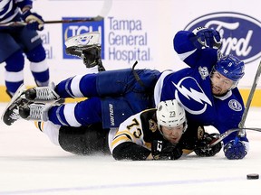 Tyler Johnson of the Tampa Bay Lightning and Charlie McAvoy of the Boston Bruins fight for the puck during Game 2 at Amalie Arena on April 30, 2018 in Tampa. (Mike Ehrmann/Getty Images)