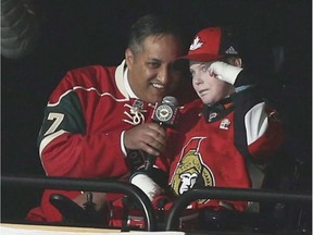 Jonathan Pitre, right, joins Canadian Consul General Khawar Nasim with the call of "Let's Play Hockey" before a Senators-Wild game in Minneapolis on March 30, 2017.