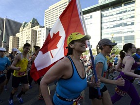 A runner holds a Canadian flag as she begins the Scotiabank Ottawa Marathon last May 28.