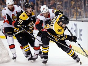 Senators forward Zack Smith, far left, and the Bruins' Noel Acciari (55) watch as Ottawa's Magnus Paajarvi and Boston's Adam McQuaid (54) battle for the puck during the first period of Saturday's game.