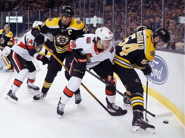 Bruins Zdeno Chara (33) and Adam McQuaid (54) team up on a puck-possession battle with Senators winger Mike Hoffman during third-period action.