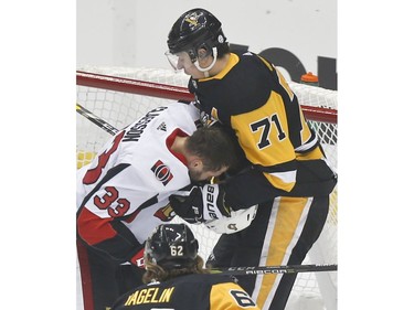 Penguins centre Evgeni Malkin pulls the helmet off Senators defenceman Fredrik Claesson (33) during the first period.