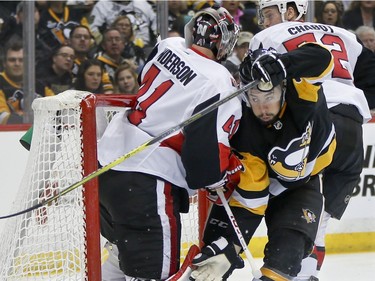 Pittsburgh's Josh Jooris, middle, is pushed by Ottawa's Thomas Chabot (72) into goaltender Craig Anderson during the second period. Chabot was penalized on the play.