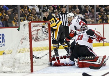 Penguins forward Jake Guentzel, left, scores on Senators netminder Craig Anderson as defenceman Fredrik Claesson looks on in the second period.