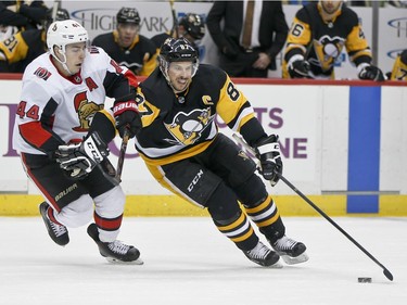 Penguins centre Sidney Crosby pushes off Senators centre Jean-Gabriel Pageau as he controls the puck during the second period.