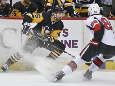 The Penguins' Zach Aston-Reese and the Senators' Christian Wolanin make sudden changes in direction during the second period.