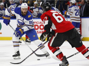 Buffalo Sabres forward Ryan O'Reilly (90) controls the puck in front of Ottawa Senators defenseman Ben Harpur (67) during the first period of an NHL hockey game Wednesday, April 4, 2018, in Buffalo, N.Y.