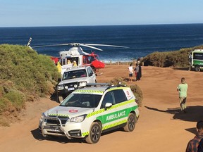 A rescue helicopter and other emergency vehicles are seen at the scene of the shark attack in Gracetown, Australia, Monday, April 16, 2018.