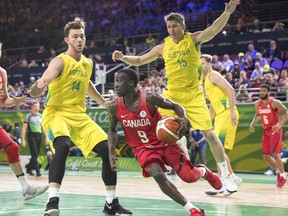 Canada's Munis Tutu tries to get around Australia's Angus Brandt (left) and Jesse Wagstaff (right) during the gold medal basketball game at the Commonwealth Games on Sunday n Gold Coast, Australia. (THE CANADIAN PRESS)