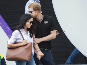 Prince Harry, right, arrives with his girlfriend Meghan Markle arrive to wheelchair tennis during the Invictus Games in Toronto on Monday, September 25, 2017. This is Prince Harry's first public appearance with Markle. THE CANADIAN PRESS/Nathan Denette ORG XMIT: NSD118