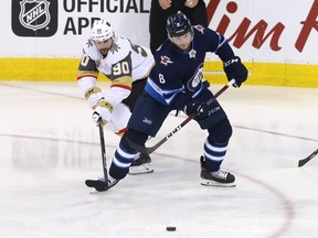 Tomas Tatar #90 of the Vegas Golden Knights and Jacob Trouba #8 of the Winnipeg Jets battle for the puck during the third period in Game Two of the Western Conference Finals during the 2018 NHL Stanley Cup Playoffs at Bell MTS Place on May 14, 2018 in Winnipeg.