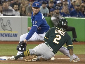 Oakland Athletics' Khris Davis slides safely into third as Toronto Blue Jays third baseman Josh Donaldson tries to make a play in the eighth inning of their American League MLB baseball game in Toronto on Saturday May 19, 2018.