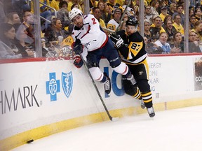 Matt Niskanen of the Washington Capitals and Sidney Crosby of the Pittsburgh Penguins slam into the boards during Game 4 at PPG PAINTS Arena on May 3, 2018