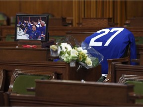 Flowers, a photograph and hockey jersey lie on the House of Commons desk of Conservative MP Gord Brown in the House of Commons on Parliament Hill, in Ottawa on Wednesday, May 2, 2018. Brown, who was the MP for Leeds-Grenville-Thousand Islands and Rideau Lakes, died suddenly at the age of 57.