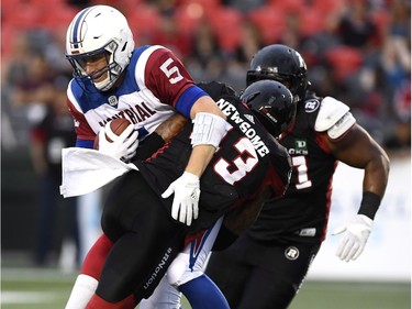 Montreal Alouettes quarterback Drew Willy (5) gets tackled by Ottawa Redblacks' Jonathan Newsome (23) during first half pre-season CFL action in Ottawa on Thursday, May 31, 2018.