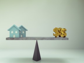 dollar sign and house on balance board