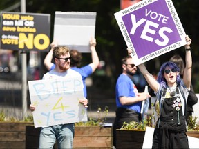 Members of the public hold yes placards on Fairview road as the country heads to polling stations on May 25, 2018 in Dublin, Ireland. (Jeff J Mitchell/Getty Images)