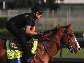 Kentucky Derby and Preakness winner Justify, ridden by exercise rider Humberto Gomez, works out at Churchill Downs, in in Louisville, Ky., yesterday. (AP)