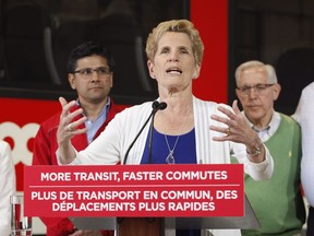 Ontario Liberal leader Kathleen Wynne speaks in front of the O-Train at a campaign stop in Ottawa on Thursday, May 17, 2018.