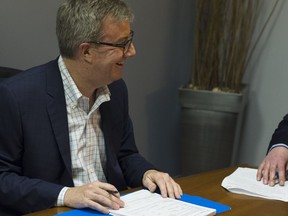 On Tues. May 1, in the City of Ottawa Elections Office, Tyler Cox, Manager of Legislative Services, assists Jim Watson officially register to run for re-election as the Mayor of Ottawa.