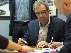 On Tues. May 1, in the City of Ottawa Elections Office, Tyler Cox, Manager of Legislative Services, and Riannon Power, Elections Coordinator, assist Jim Watson officially register to run for re-election as the Mayor of Ottawa.