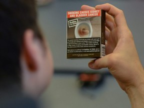 Ottawa high school students look at plain cigarette packaging examples, on World No Tobacco Day, prior to meeting with Minister of Health Jane Philpott in Ottawa on May 31, 2016.