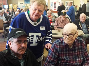 The legendary Murray “Happy Motoring” Westgate recently celebrated his 100th birthday with his many friends at the Sunnybrook Veterans Centre. Several days later, a few of Murray’s friends from the NHL Old Timers Original 6 Toronto group visited the centre where they chatted with the veterans and presented Murray with a special Toronto Maple Leaf sweater complete with the number 100 on the back. In this photo, club member Jim Amodeo and I (wearing my Toronto Arenas hockey club shirt, a Christmas gift from my wife) congratulate Murray as he waits until we leave so he can try on his unique shirt.
