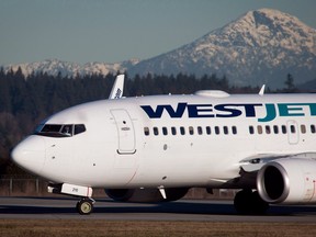 A pilot taxis a Westjet Boeing 737-700 plane to a gate after arriving at Vancouver International Airport in Richmond, B.C., on February 3, 2014. WestJet Airlines Ltd. say its first-quarter profit fell compared with a year ago after what it called a challenging quarter. The airline says it earned $37.2 million or 32 cents per diluted share, down from $46.7 million or 40 cents per diluted share a year ago. THE CANADIAN PRESS/Darryl Dyck