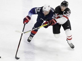 Alec Martinez of the United States, left, challenges for the puck with Canada's Connor McDavid during the Ice Hockey World Championships bronze medal match between Canada and the United States at the Royal arena in Copenhagen, Denmark, Sunday, May 20, 2018.